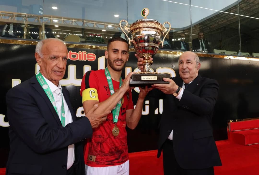 Le président de la République M. Abdelmadjid Tebboune remet le trophée de la Coupe d'Algérie 2025 au capitaine de l'USM Alger.