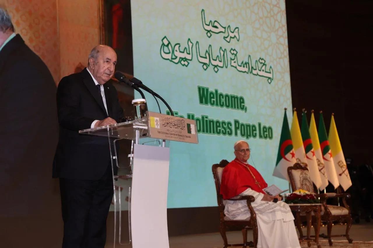  I wekked uselway n Tegduda, Mass abdelmadjid Tebboune ass-a, asmuteg n Dzayer ɣef ukemmel n umahil tgara n uwanak n Vatikan ɣef usmal n wazalen n umfahem d udiwenni dtezdellit d unmireg.
Deg wawal i d-yenna deg wammas adelsan n Tmesgida n Dzayer, deg wattal n tirzi tunṣibt I d-yetteg ubaba Léon XIV ɣer Dzayer, yutla-d uselway n Tegduda tgara n ubaba uqdis yenna-s: “ad awen-ulseɣ asmuteg n Dzayer ummid ɣef ukemmel n umahil tgara n uwanak n Vatikan ɣef usmal n wazalen n umfahem deg wadeg n beṭṭu, d usmal n wazalen n udiwenni deg wadeg n teyyita, d usegder n wazalen n tezdellit d unmireg deg wadeg n wguren”.